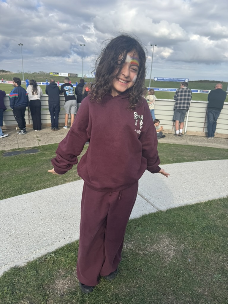 Giorgia smiling with rainbow face paint at the Miracle for Maddi celebrity charity football fundraiser in Essex.